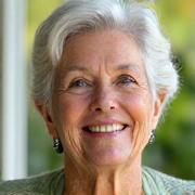 Portrait of Maria Rodriguez, 65, with a serene smile.