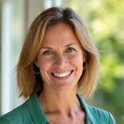 Portrait of Sarah Miller, 52, smiling warmly.