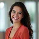 Headshot of Maria Gonzalez, a corporate wellness facilitator smiling warmly in a bright, professional setting